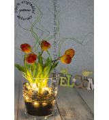 Modern jarní designová bytová dekorace s barevnými tulipány ve skleněné nádobě.